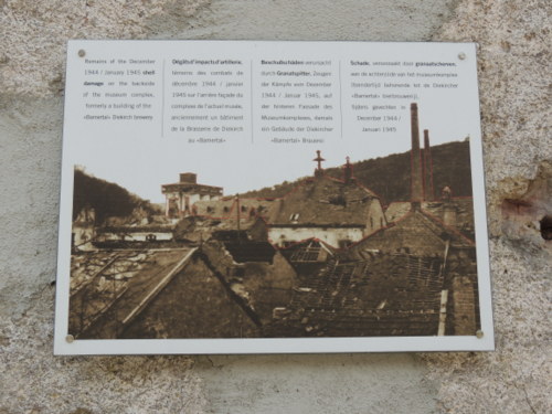 Plaque explaining the 1942 World War II shrapnel damage to the